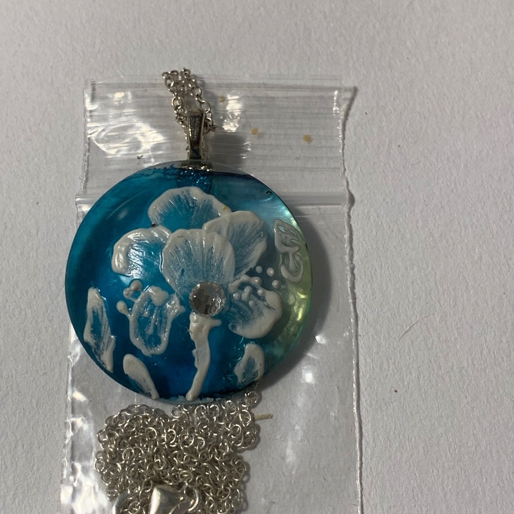 Blue handmade glass pendant necklace with textured white iris design